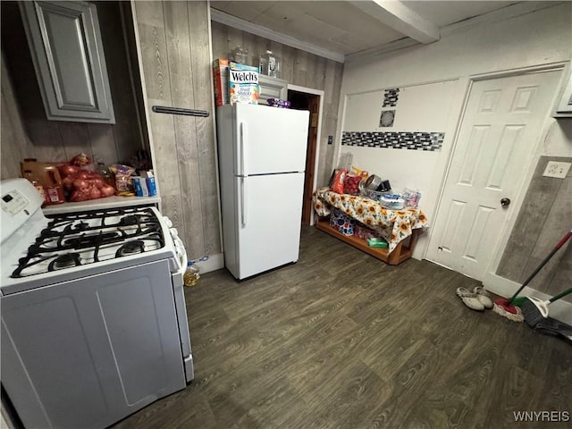kitchen featuring dark wood finished floors, white appliances, wood walls, light countertops, and beam ceiling