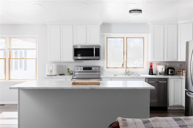 kitchen with a sink, white cabinetry, and stainless steel appliances
