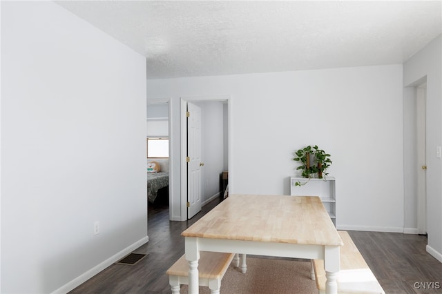 home office with visible vents, baseboards, a textured ceiling, and dark wood finished floors