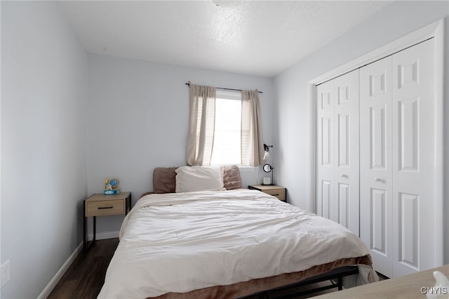bedroom with dark wood-style floors, a closet, and baseboards