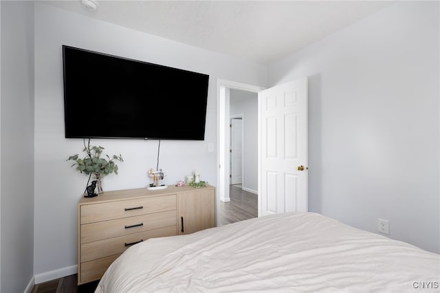 bedroom featuring baseboards and dark wood finished floors