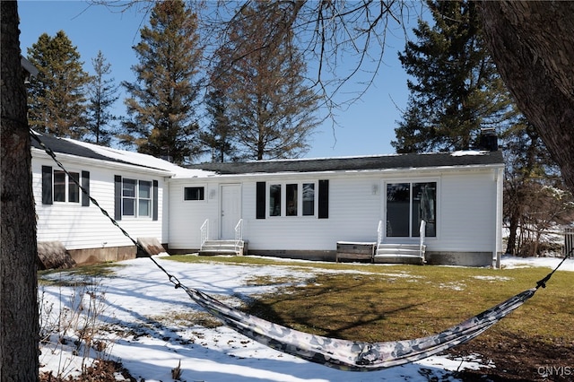 view of front of house featuring a yard, entry steps, and a chimney