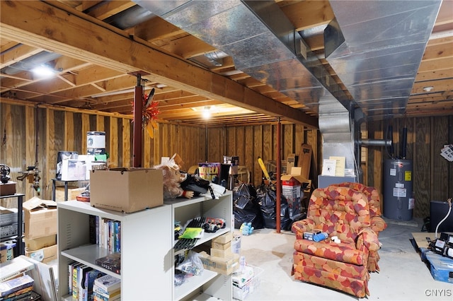 unfinished below grade area featuring wood walls and water heater