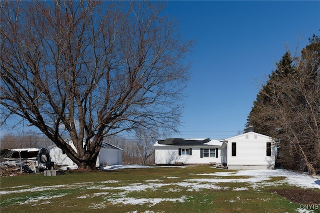 view of front of property with a lawn and an outbuilding