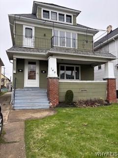 traditional style home with a front lawn and a balcony