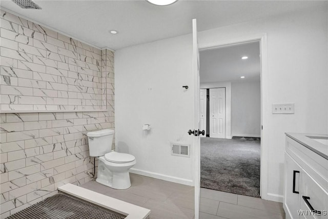 bathroom with vanity, recessed lighting, toilet, visible vents, and tile walls