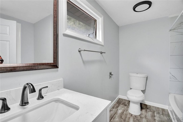 full bathroom featuring toilet, wood finished floors, vanity, and baseboards