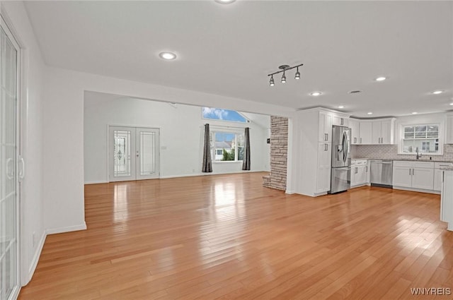 unfurnished living room featuring light wood finished floors, baseboards, and recessed lighting