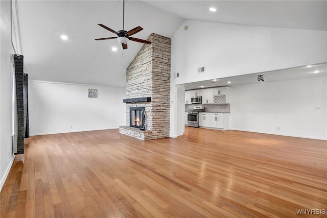unfurnished living room featuring ceiling fan, light wood-style flooring, visible vents, a stone fireplace, and baseboards