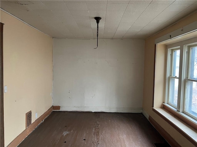 unfurnished dining area with a healthy amount of sunlight, visible vents, and hardwood / wood-style flooring