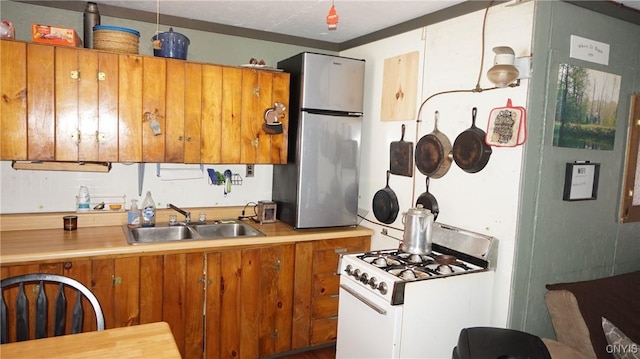 50 Apache Springs Rd, Boylston, NY 13083 - kitchen featuring a sink, freestanding refrigerator, white gas stove, brown cabinetry, and light countertops