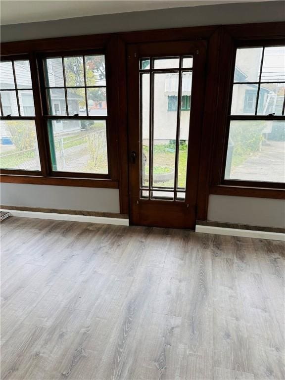 doorway with wood finished floors and baseboards
