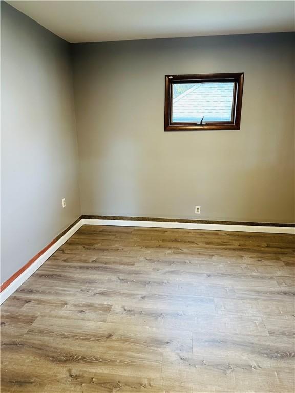 empty room featuring baseboards and wood finished floors