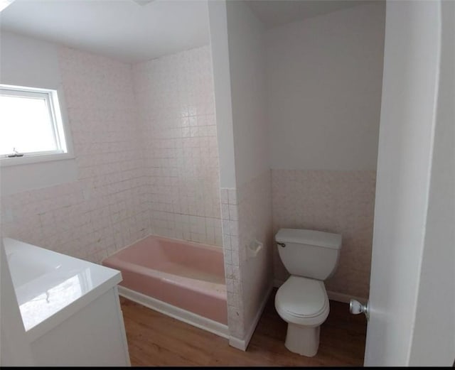 full bath with tile walls, toilet, vanity, and wood finished floors