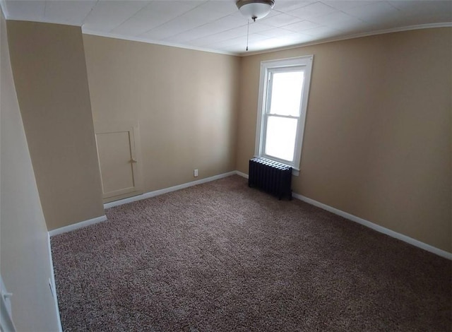 carpeted empty room featuring ornamental molding, radiator heating unit, and baseboards
