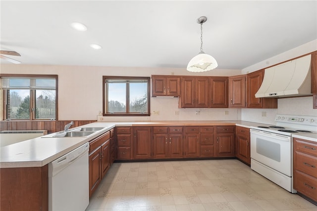 kitchen featuring white appliances, light countertops, a sink, and ventilation hood