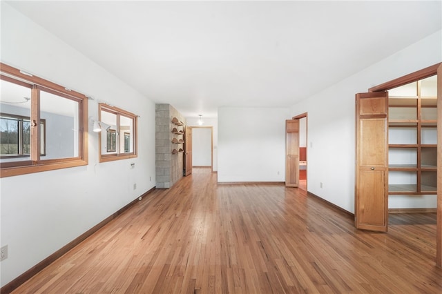 unfurnished living room with light wood finished floors and baseboards