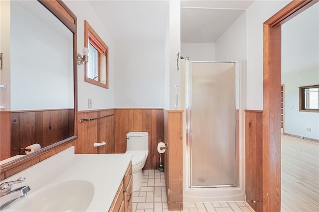 full bath with vanity, a wainscoted wall, toilet, a stall shower, and wooden walls