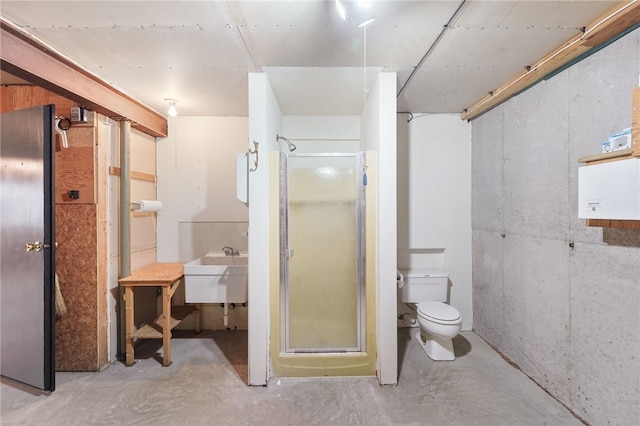full bath with a shower stall, concrete flooring, a sink, and toilet