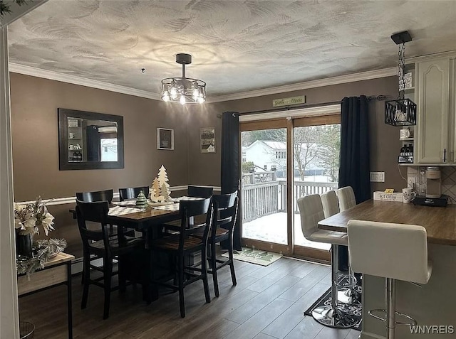 dining area with a textured ceiling, wood finished floors, an inviting chandelier, and ornamental molding