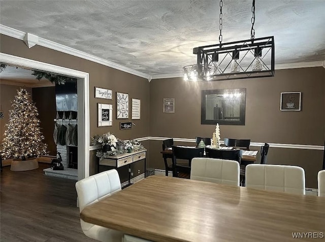 dining room with a textured ceiling, wood finished floors, and ornamental molding
