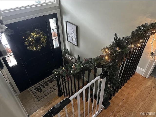 foyer entrance featuring wood finished floors, baseboards, and stairs