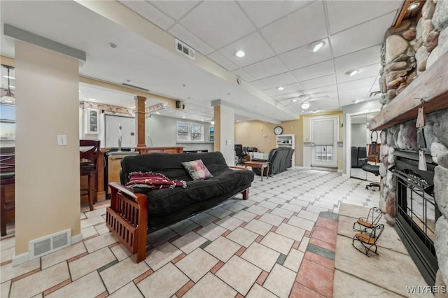 1465 Genesee St, Pembroke, NY 14036 - living room featuring a paneled ceiling, a fireplace, a ceiling fan, and visible vents