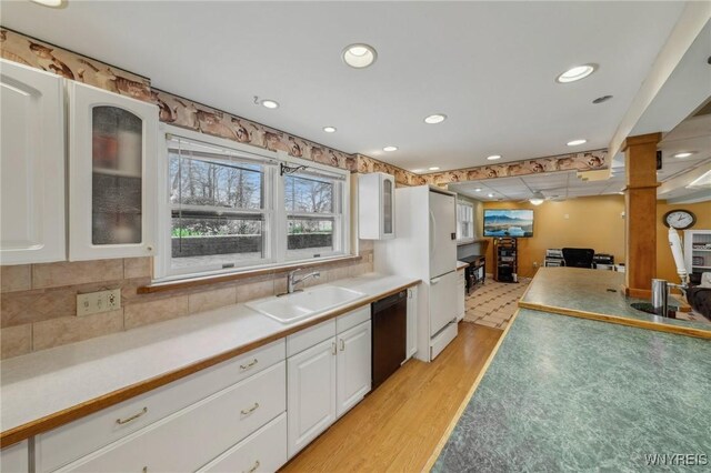 1465 Genesee St, Pembroke, NY 14036 - kitchen featuring light wood-style flooring, glass insert cabinets, dishwasher, a sink, and white cabinetry