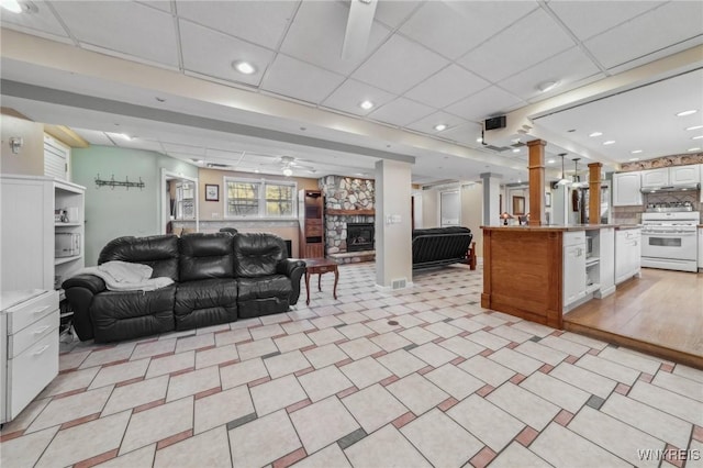 1465 Genesee St, Pembroke, NY 14036 - living area featuring a drop ceiling, a fireplace, ceiling fan, and ornate columns