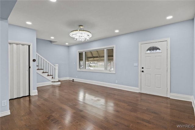 foyer entrance featuring baseboards, a chandelier, recessed lighting, wood finished floors, and stairs