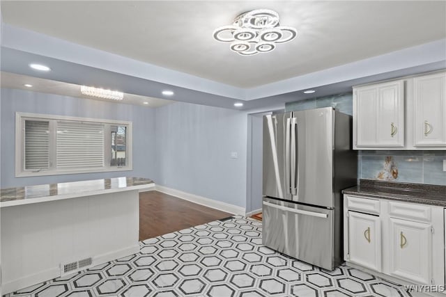 kitchen with recessed lighting, visible vents, white cabinetry, and freestanding refrigerator