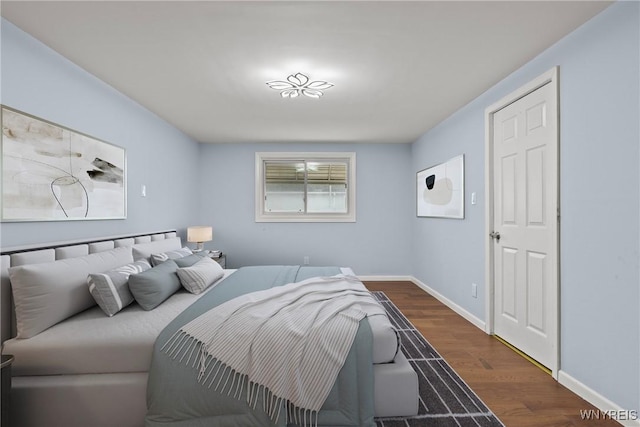 bedroom with baseboards and wood finished floors