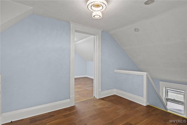 bonus room with baseboards, vaulted ceiling, and wood finished floors