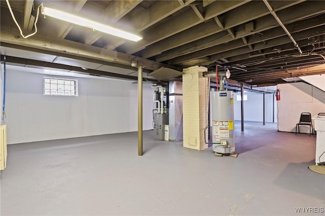 basement featuring water heater and heating unit