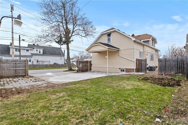 back of house with a patio, a lawn, fence, and central AC