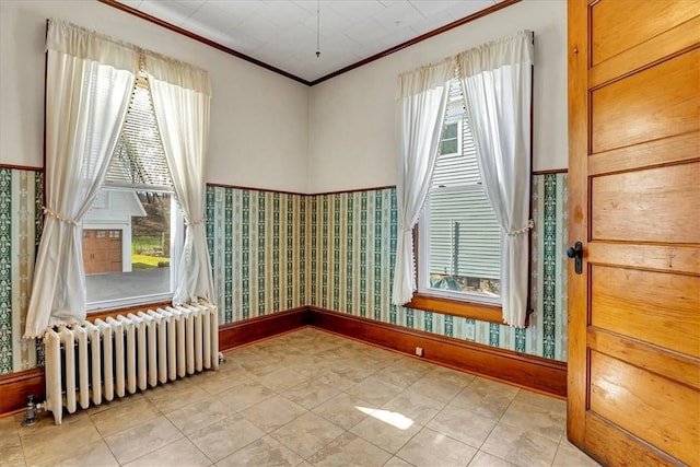 empty room featuring radiator heating unit, wallpapered walls, and a healthy amount of sunlight