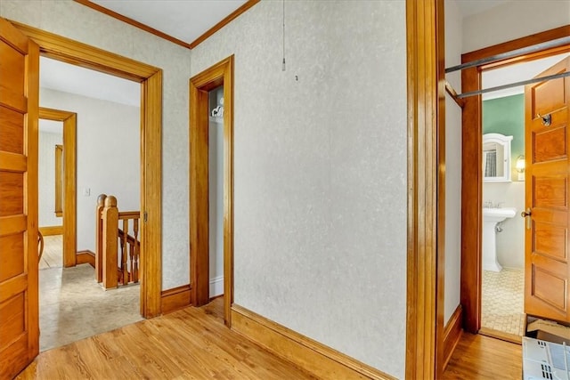 corridor with crown molding, baseboards, and wood finished floors