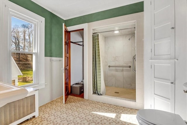 full bath featuring toilet, tile patterned floors, crown molding, and a stall shower