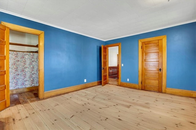 unfurnished bedroom featuring wood-type flooring, baseboards, and ornamental molding