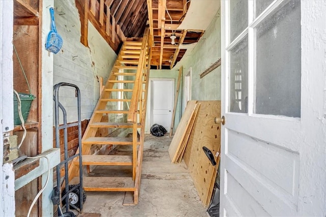 stairs featuring concrete flooring