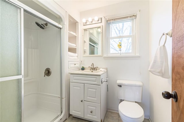 bathroom with a shower stall, vanity, and toilet