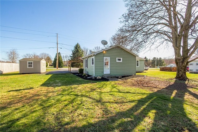 exterior space featuring an outbuilding, a yard, and a storage unit