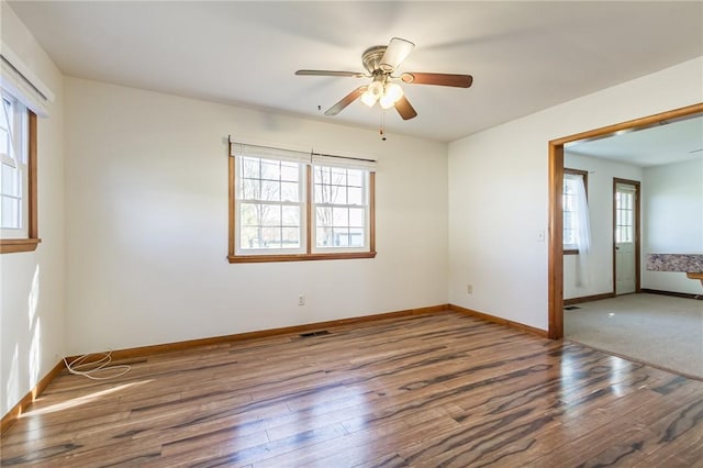 spare room featuring baseboards, a ceiling fan, and hardwood / wood-style flooring