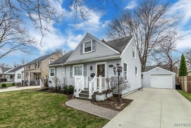 view of front of property with a garage, central AC, an outdoor structure, a front yard, and driveway
