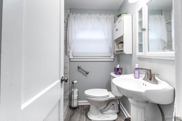 bathroom with toilet and wood finished floors