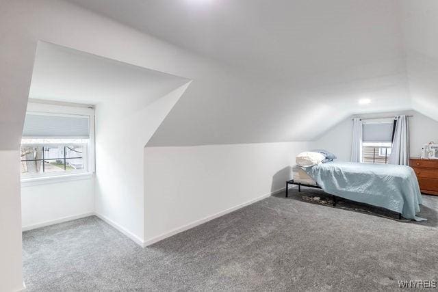 carpeted bedroom featuring baseboards and vaulted ceiling
