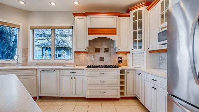 367 Waters Edge, Owasco, NY 13021 - kitchen featuring appliances with stainless steel finishes, light countertops, decorative backsplash, recessed lighting, and glass insert cabinets