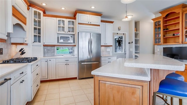 367 Waters Edge, Owasco, NY 13021 - kitchen featuring stainless steel fridge, gas cooktop, a breakfast bar area, light countertops, and decorative backsplash