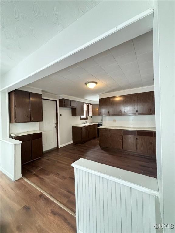 149 River St, Rome-Inside, NY 13440 - kitchen featuring light countertops, baseboards, dark wood-style floors, and dark brown cabinetry