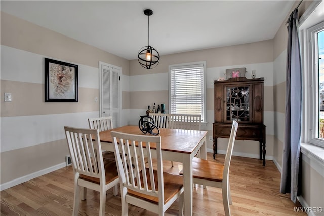 dining area featuring light wood-style flooring, plenty of natural light, and baseboards